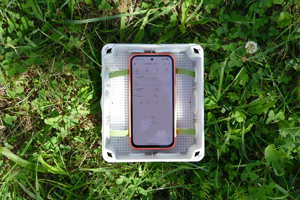 Smartphone mit BirdNET Live App in einer Abzweigdose aus dem Baumarkt.